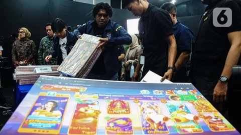 Petugas merapikan barang bukti usai sejumlah Menteri Kabinet Merah Putih memberikan keterangan terkait capaian desk pemberantasan perjudian daring dan desk keamanan siber dan perlindungan data di Kantor Kementerian Komunikasi dan Digital (Komdigi), Jakarta, Kamis (21/11/2024). (Liputan6.com/Angga Yuniar)
