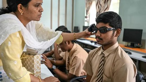 Sebuah sekolah tunanetra di Hyderabad, India menggelar program pelatihan dan pengenalan sekaligus penggunaan kacamata pintar berteknologi Artificial intelligence (AI) untuk para siswa disabilitas netra. (NOAH SEELAM/AFP)