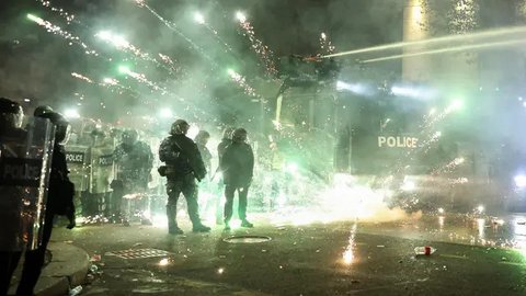 Para pengunjuk rasa menembakkan kembang api ke arah polisi pada hari keempat protes nasional menentang keputusan pemerintah untuk menunda pembicaraan keanggotaan Uni Eropa di Tbilisi pada tanggal 2 Desember 2024. (Giorgi ARJEVANIDZE/AFP)