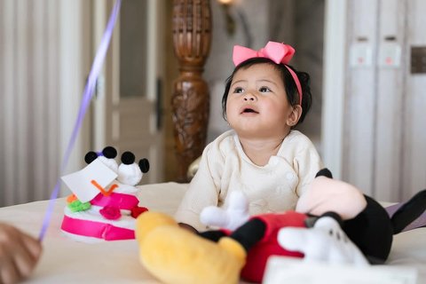 Potret Lily dengan Pita Pink di Kepala, Super Gemas Pose di Atas Kasur