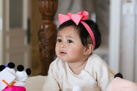 Potret Lily dengan Pita Pink di Kepala, Super Gemas Pose di Atas Kasur