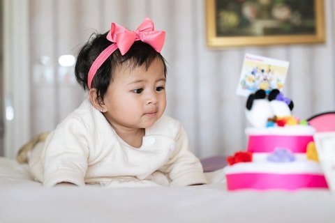 Potret Lily dengan Pita Pink di Kepala, Super Gemas Pose di Atas Kasur