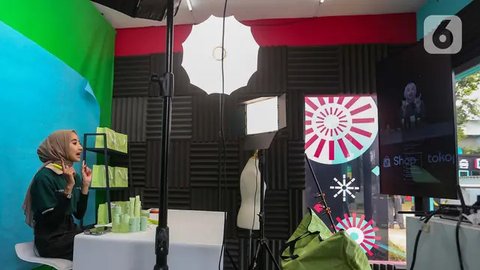Afiliator saat menawarkan produk secara daring atau online dengan melakukan siaran langsung melalui aplikasi di dalam kotak studio siaran saat Hari Belanja Online Nasional (Harbolnas) 1212 di Jakarta, Kamis (12/12/2024). (Liputan6.com/Angga Yuniar)