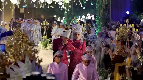 Selama prosesi jalan ke pelaminan, Zumi dan Putri saling bertatapan mesra. Sesekali Zumi mencium tangan sang istri dengan penuh cinta.