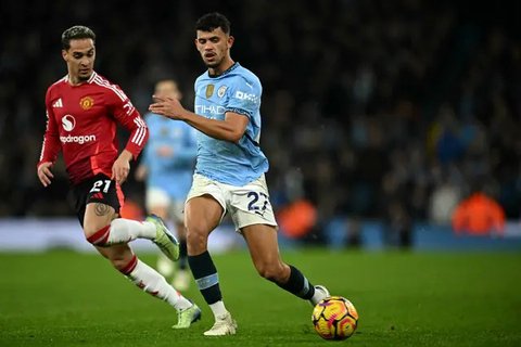 Gelandang Manchester City asal Portugal #20, Bernardo Silva, bereaksi saat gelandang Manchester United asal Pantai Gading #16, Amad Diallo, merayakan gol kedua tim selama pertandingan Liga