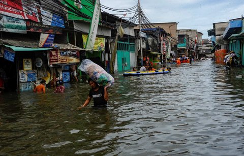 Sejumlah warga beraktivitas saat banjir rob melanda kawasan Muara Angke, Jakarta, Senin (16/12/2024).
