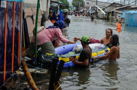 Warga dievakuasi menggunakan perahu karet saat banjir rob melanda kawasan Muara Angke, Jakarta, Senin (16/12/2024).