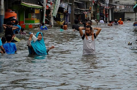 Sejumlah warga beraktivitas saat banjir rob melanda kawasan Muara Angke, Jakarta, Senin (16/12/2024).