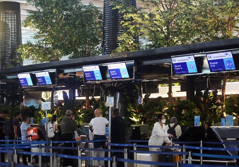 Penumpang pesawat  melakukan check-in pada konter  dengan suasana tanaman tropis di Terminal 3 Bandara Internasional Soekarno Hatta, Tangerang, Banten, Selasa (17/12/2024).
