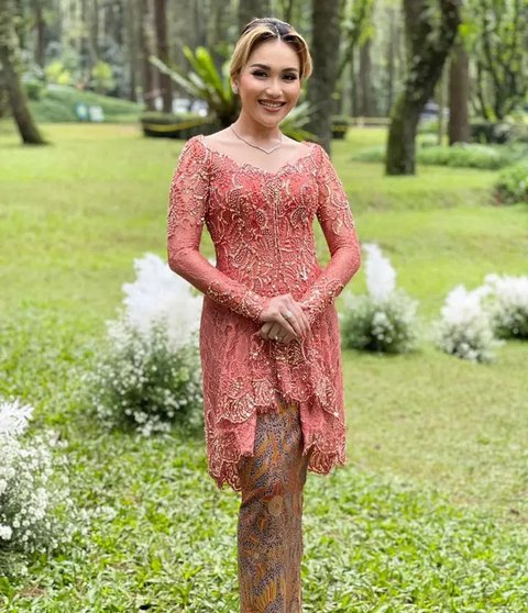 Perpaduan kebaya payet warna nude dan rok batik merah ini begitu menawan. Aksen side slit makin menambah kesan modern! (Instagram/prillylatuconsina96)