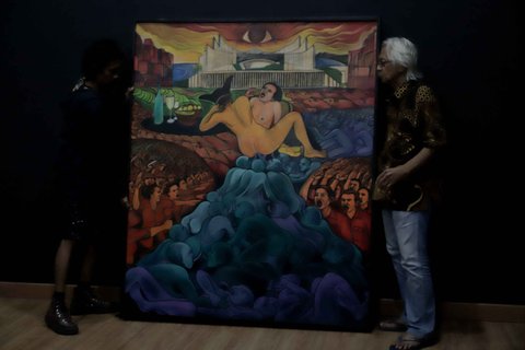 Seniman senior Yos Suprapto (kanan) menurunkan salah satu lukisan setelah pameran karya seni bertajuk 'Kebangkitan: Tanah Untuk Kedaulatan Pangan' dihentikan di Galeri Nasional Indonesia, Jakarta, Senin (23/12/2024).