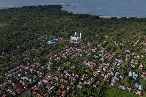 Foto udara memperlihatkan kondisi terkini Masjid Rahmatullah dan pemukiman di sekitarnya, salah satu kawasan yang rusak parah akibat tsunami pada 20 tahun lalu, di Lampuuk, Lhoknga, Aceh Besar, Aceh, pada 22 Desember 2024.