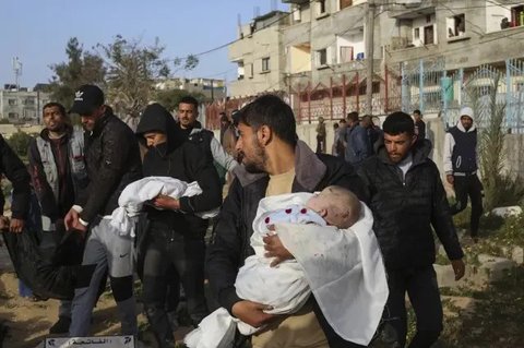 Seorang anak perempuan Palestina menunggu dalam antrean untuk menerima makanan di luar pusat distribusi di selatan Khan Yunis pada 6 Desember 2024. (BASHAR TALEB/AFP)