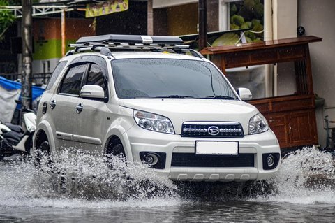 Daihatsu Terios melintasi genangan air di musim hujan.
