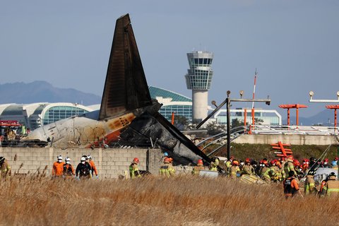 Tim SAR melakukan penyelamatan  di dekat bagian ekor pesawat Boeing 737-800  Jeju Air yang jatuh dan terbakar  di Bandara Internasional Muan di Provinsi Jeolla Selatan, Korea Selatan, Minggu (29/12/2024).