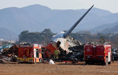 Tim SAR melakukan penyelamatan  di dekat bagian ekor pesawat Boeing 737-800  Jeju Air yang jatuh dan terbakar  di Bandara Internasional Muan di Provinsi Jeolla Selatan, Korea Selatan, Minggu (29/12/2024).
