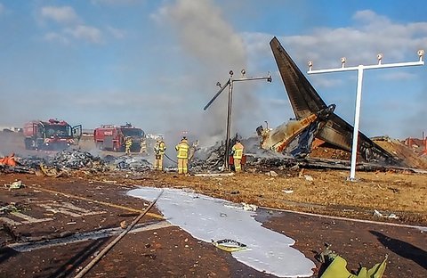 Tim SAR melakukan penyelamatan  di dekat bagian ekor pesawat Boeing 737-800  Jeju Air yang jatuh dan terbakar  di Bandara Internasional Muan di Provinsi Jeolla Selatan, Korea Selatan, Minggu (29/12/2024).