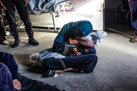 Seorang wanita Palestina menggendong jenazah seorang anak yang tewas akibat serangan udara Israel di sebuah klinik kesehatan di daerah Tel al-Sultan, Rafah, Jalur Gaza, pada 26 Mei 2024.