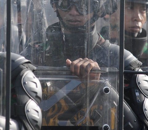 Barisan prajurit TNI AD dengan tameng dan pakaian pelindung lengkap saat mengikuti Apel Gelar Pasukan Pengamanan Pemilu Tahun 2024 di Lanud Halim Perdanakusuma, Jakarta, Kamis (1/2/2024). Foto: Merdeka.com/Imam Buhori