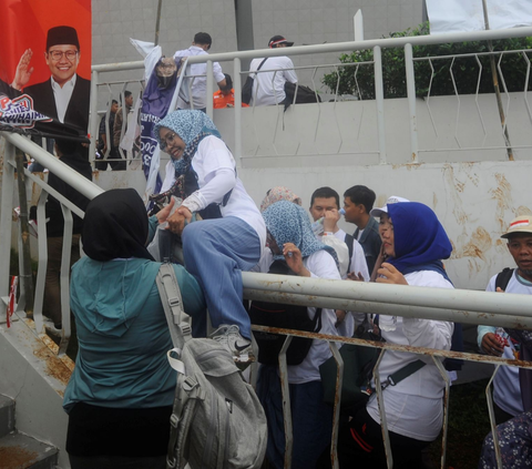 Salah satu pendukung pasangan Capres dan Cawapres nomor urut 1 Anies Baswedan-Muhaimin Iskandar (AMIN) nekat sampai memanjat pagar pintu masuk  Jakarta International Stadium (JIS), Jakarta, Sabtu (10/02/2024). Foto: merdeka.com / Arie Basuki<br>