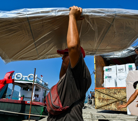 Pekerja mengangkat logistik pemilu ke atas perahu saat akan diantar menuju pulau-pulau terpencil, di Pulo Aceh, di Banda Aceh, Senin (12/2/2023). Foto: AFP / CHAIDEER MAHYUDDIN