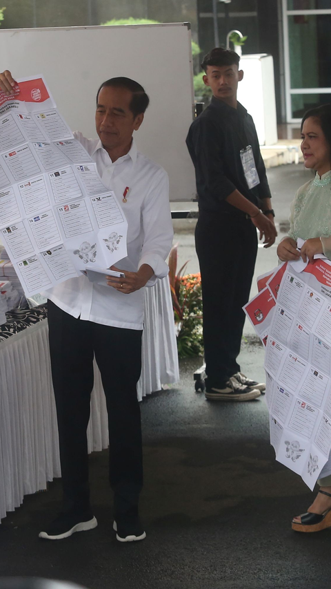 Jokowi sempat membuka lembaran surat suara sebelum menuju ke bilik pencoblosan. Foto: merdeka.com / Arie Basuki