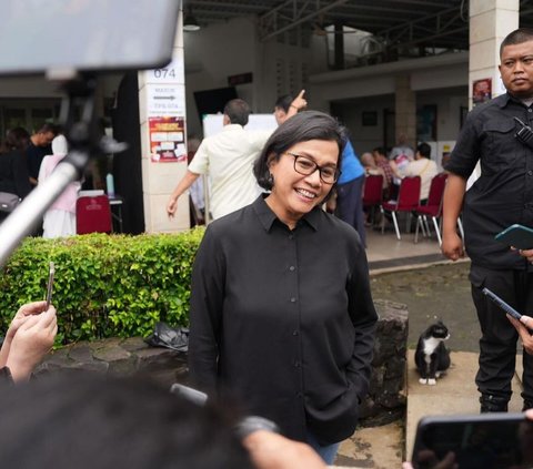 Wearing a black shirt, Here's the Trick of Minister of Finance Sri Mulyani Posing with Fingers Dipped in Ink for the 2024 Election