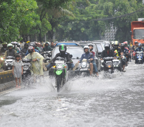 Kendaraan bermotor menerobos banjir di Jalan Daan Mogot, Jakarta Barat, Rabu (14/02/2024). Banjir yang terjadi akibat luapan kali Sekretaris menyebabkan kemacetan lalu lintas. Foto: merdeka.com / Arie Basuki<br>