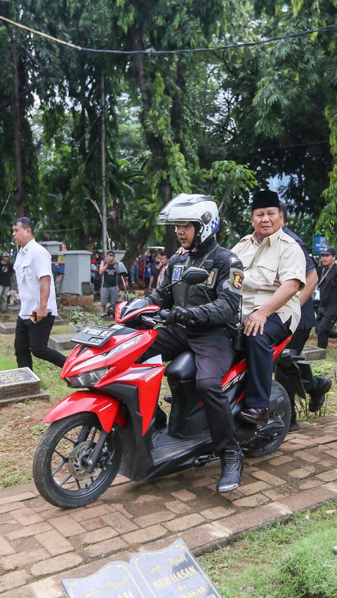 Prabowo tampak menaiki sepeda motor merah saat menuju ke pusara Soemitro.
