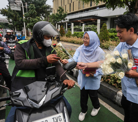Tim Kampanye  Nasional (TKN) Pemilih Muda (Fanta) Prabowo-Gibran membagikan bunga mawar dan coklat kepada pengguna jalan di Kawasan Sarinah, Jakarta, Kamis (15/2/2024). Foto: Liputan6.com / Angga Yuniar