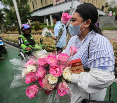 Tim Kampanye  Nasional (TKN) Pemilih Muda (Fanta) Prabowo-Gibran saat membagikan bunga mawar dan coklat kepada pengguna jalan di Kawasan Sarinah, Kamis (15/2/2024). Foto: Liputan6.com / Angga Yuniar
