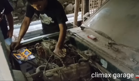 Seorang pria teknisi mesin mencoba memeriksa kondisi mesin dari mobil Mazda 808 tersebut. <br>