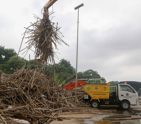 Tumpukan bambu yang merupakan limbah alat peraga kampanye dipindahkan menggunakan alat berat di tempat penyaringan sampah di TB Simatupang, Jakarta, Jumat (16/2/2024). Dinas Lingkungan Hidup (DLH) DKI Jakarta mengumpulkan sampah alat peraga kampanye (APK) untuk didaur ulang. Liputan6.com/Herman Zakharia