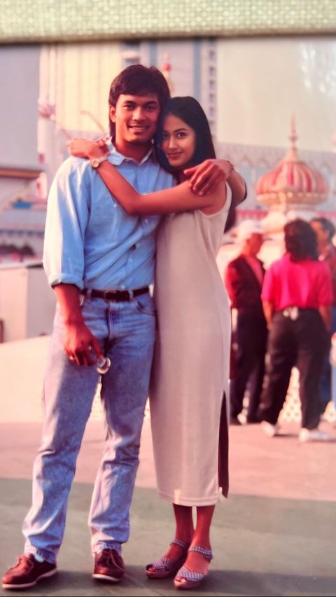 Perempuan kelahiran 1971 ini tampil cantik dengan mengenakan long dress tanpa lengan. 