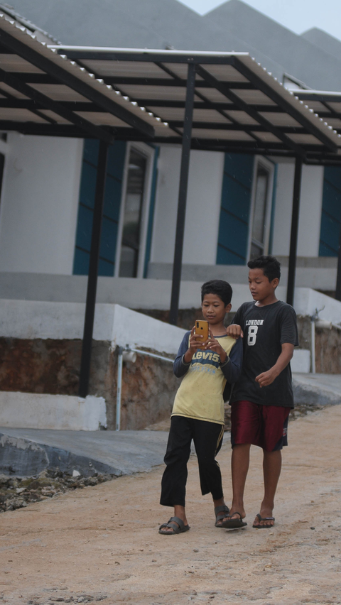Dua orang anak saat melakukan menggunakan dompet digital dengan aplikasi Gopay di Desa Kubang, Kabupaten Bogor, Jawa Barat, Sabtu (17/2/2024). Foto: merdeka.com / Imam Buhori