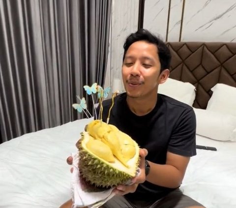 Selanjutnya, sang suami mengambil 'kue' ulang tahun durian ini dan meniup lilin.