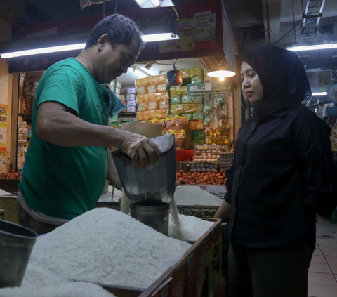 Pedagang beras sedang melayani pembeli bahan pokok tersebut di tengah harga beras yang melonjak tajam di Pasar Cibubur, Jakarta, Senin (19/2/2024). Foto: Liputan6.com / Herman Zakharia.
