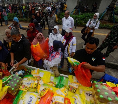 Petugas saat melayani warga yang antre saat memberi beras dan sembako murah di kegiatan Pasar Murah di halaman kantor Kecamatan Pamulang, Tangsel. Foto: merdeka.com / Arie Basuki