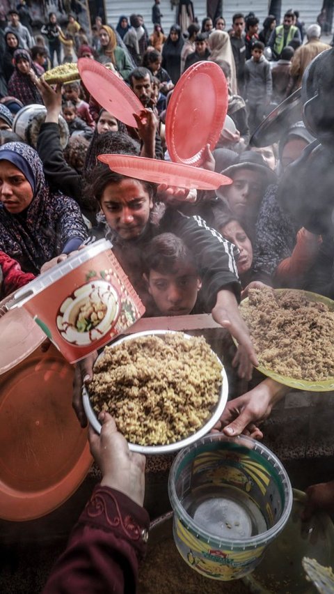 Di sebuah sekolah pemerintah yang diubah menjadi kamp pengungsian, warga Palestina menghadapi kelaparan. Mohammed Abed/AFP