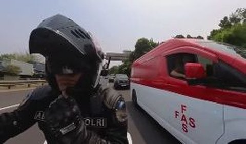 Seorang anggota polisi bernama Bripka Abster memberikan pengawalan kepada sebuah mobil ambulans saat berada di jalan tol.