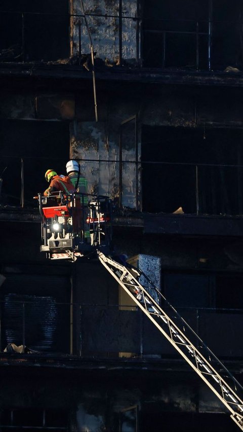 Petugas pemadam saat berjibaku menjinakkan titik api pada gedung apartemen yang terbakar hebat di Valencia, Spanyol, Kamis (22/2/2024). Jose Jordan/AFP