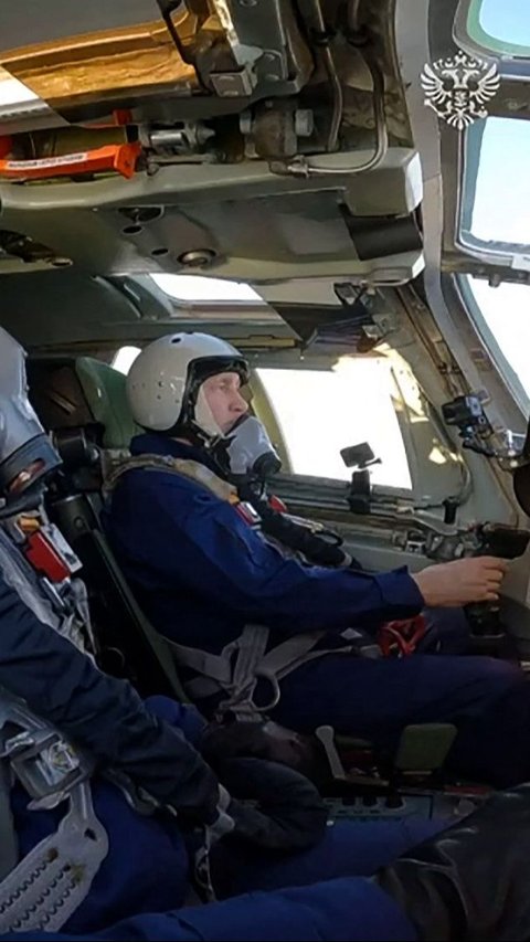 Putin terlihat duduk di kursi kopilot dengan memakai helm dan masker oksigen selama menerbangkan pesawat pengebom tersebut. 