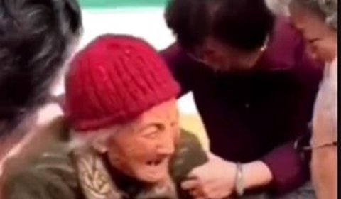 Dalam video yang beredar di media sosial, tampak seorang wanita tua berteriak histeris sembari memeluk seorang kakek yang duduk di kursi roda.