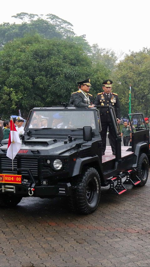 Di atas sebuah mobil dengan atap terbuka, Prabowo tampak meninjau alat tempur dengan memakai seragam TNI yang dilengkapi pangkat bintang 4 dan sederet tanda kehormatan. Liputan6.com/Herman Zakharia 