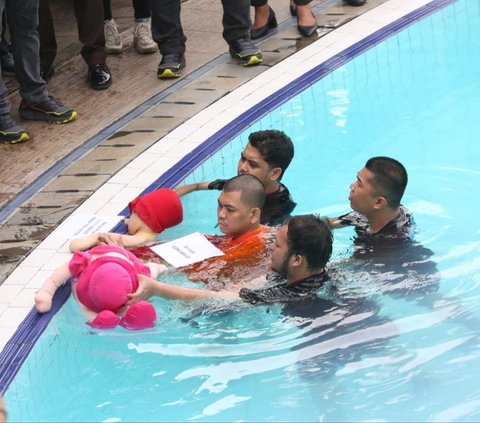 Tiga anggota kepolisian terlihat mengawal tersangka Yudha saat reka ulang dilakukan di kolam renang tersebut. Foto : Kapanlagi.com / Budy Santoso