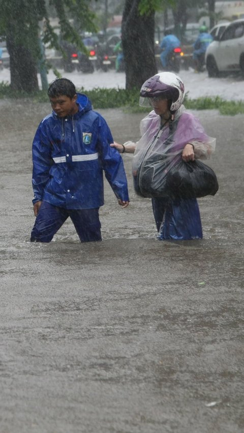 Warga menerobos banjir banjir yang menggenangi Jalan Suprapto, Cempaka Putih, Jakarta Pusat, Kamis (29/02/2024). Merdeka.com/Arie Basuki