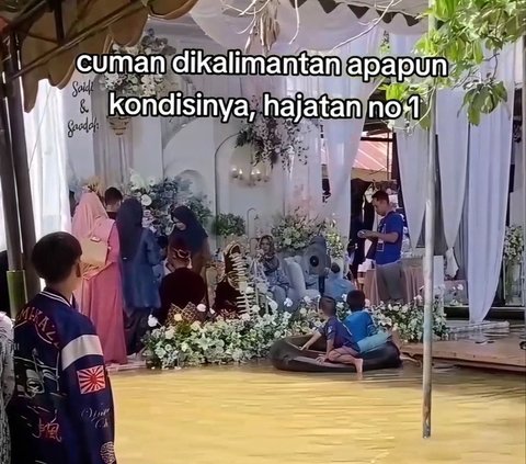 Residents Still Hold Wedding Celebrations Despite Floodwaters as High as Knees, Distracted by Children Playing in Water Near the Wedding Stage