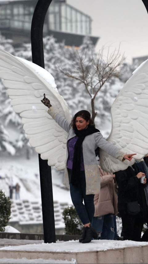 Turunnya salju di Iran ini juga membuat warga Iran terkejut sekaligus bahagia karena mereka dapat menikmati pemandangan yang indah.<br>(Foto ATTA KENARE / AFP)<br>