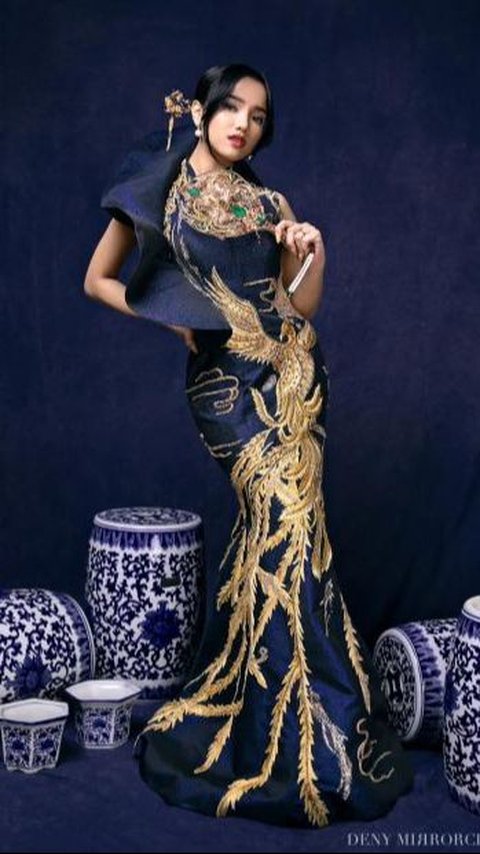 Fuji looks glamorous wearing a dark blue elegant mermaid dress with gold peacock embroidery details that cover the entire dress.