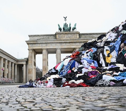 FOTO: Protes Dampak Fast Fashion, Aktivis Lingkungan Pajang Gunungan Sampah Pakaian Bekas di Berlin